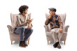 Young man with curly hair and glasses sitting in an armchair and talking to an elderly man