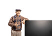 Elderly man leaning on a new flat lcd tv screen and pointing
