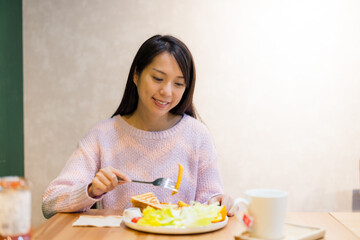 Canvas Print - Woman enjoy her meal at coffee shop