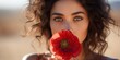 Young woman in a vintage dress holding a red poppy flower up to her face in a vibrant field of poppies. Generative AI.