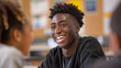 In a dynamic classroom scene, a male student beams with a genuine smile as he interacts with peers, capturing a moment of shared joy and friendship amidst the backdrop of academic