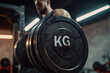 A man is lifting a weight in a gym. The weight is labeled with the letters KG