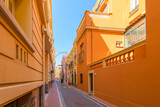 Fototapeta Uliczki - A narrow, colorful alley street in the colorful old town medieval district on the Rock along the Cote d'Azur in Monaco City, Monaco
