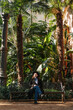 Vertical portrait of a peaceful woman sitting on a bench in a spanish greenhouse.