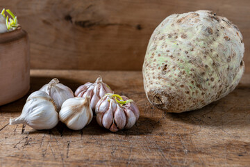 Organic garlic and fresh celery root on rustic wooden table. Food background.