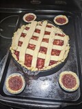 Fototapeta Uliczki - A baked strawberry rhubarb pie with the traditional lattice crust pattern. On top of the stove top with some mini ones beside it