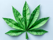 A green origami artwork resembling a cannabis leaf on a white background with a symmetrical design.
