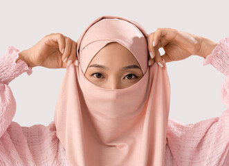 Sticker - Beautiful young Asian woman in hijab on grey background