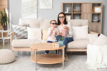 Canvas Print - Beautiful mother and her cute little daughter in 3D cinema glasses with popcorn watching movie at home