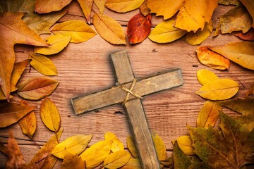 Wall Mural - Wooden christian Cross with autumn leaf