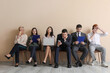 © Pixel-Shot - Applicants waiting for job interview near beige wall