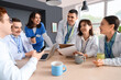 © Pixel-Shot - Team of doctors having coffee break at table in hospital kitchen