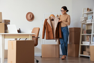 Poster - Female Asian seller with sheepskin coat in warehouse store