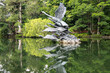 Statue of swans and its reflection in the lake at Singapore's Botanical Garden