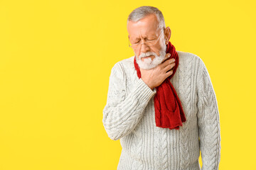 Wall Mural - Ill old man with sore throat on yellow background