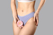 © Pixel-Shot - Young woman in panties with beautiful pink flower on grey background
