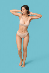 Poster - Beautiful young woman in underwear on blue background