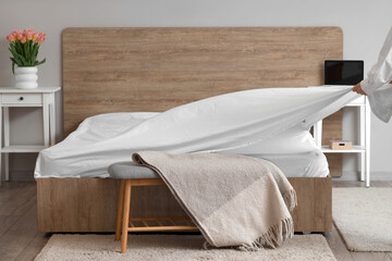 Poster - Woman making bed in modern bedroom