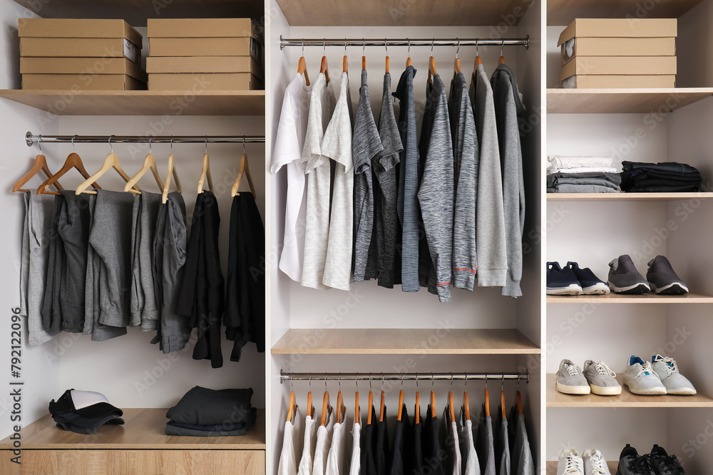 Rack with stylish male clothes and accessories in modern wardrobe