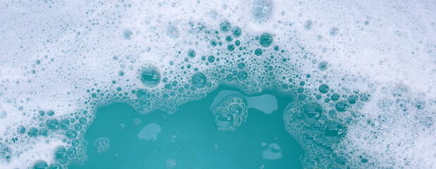 Wall Mural - Detergent foam bubble on water. Blue background, Soap sud