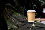 Fototapeta  - paper cup of coffee in green garden
