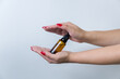 Product package with serum and a woman hand in studio on a background