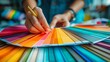 © Suryani - Close-up of hands selecting color swatches for design project, concept of creativity and color theory in art and decoration