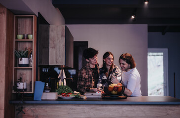 Poster - Close friends gathered around the kitchen counter at home, enjoying each other's company and a hearty meal.