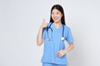 Smiling young woman doctor with stethoscope showing thumbs up isolate on white background.