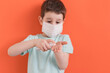 Child in medical mask with sanitizer