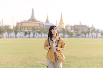 Wall Mural - A Traveler Asian woman in her 30s exploring Wat Pra Kaew. From stunning architecture to friendly locals, she cherishes every moment, capturing it all in her heart and camera for years to come.