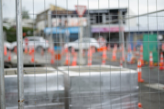 Building materials fenced off on a construction site. Selective focus on the metal fence. Auckland.