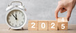 Happy New Year with vintage alarm clock and hand flipping 2024 change to 2025  block. Christmas, New Start, Resolution, countdown, Goals, Plan, Action and Motivation Concept