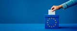 Fototapeta Perspektywa 3d - Voting for the European Union election, a hand putting a ballot paper into a ballot box on a blue background with copy space