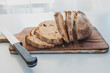 dark rye bread cut into slices on rustic chopping board, simple healthy food