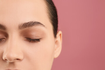 Poster - Young woman with perfect eyebrows on pink background, closeup. Space for text