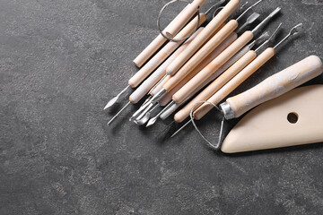 Wall Mural - Set of different clay crafting tools on grey table, top view. Space for text