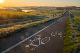 Fototapeta Miasto - Cycle road running through beautiful spring countryside during foggy, sunny morning