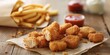 Delicious crispy chicken nuggets served with a side of golden french fries on rustic wood.