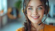 A photo of a beautiful young woman with freckles wearing a headset and smiling.
