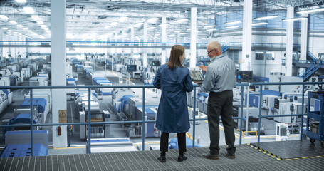Poster - Middle Aged Engineer and Young Japanese Technician Having a Conversation and Using Laptop Computer. Specialists Monitoring, Analyzing Software Reports at a Modern Electronics Factory