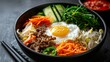 Artistic presentation of Bibimbap, highlighting its mix of vegetables, beef, and egg, enriched with gochujang sauce, on an isolated backdrop, studio lighting