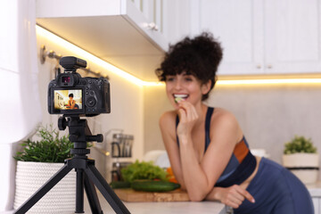 Wall Mural - Food blogger recording video in kitchen, focus on camera