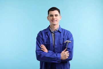 Canvas Print - Professional repairman holding hammer on light blue background