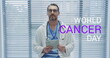 Image of world cancer day over caucasian male doctor using tablet