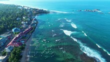 Aerial Drone Landscape Of Coastline Headland With Charter Boats Docked Near Restaurants Resort Hotels In Turtle Beach Bay In Hikkaduwa Sri Lanka Asia Travel Holidays