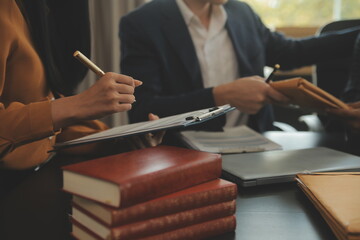 Justice and Law concept. Legal counsel presents to the client a signed contract with gavel and legal law or legal having team meeting at law firm in background