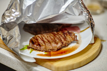 Wall Mural - Grilled steak resting under aluminum foil before serving