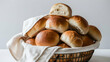 Warm, golden-brown dinner rolls, freshly baked and enticing, placed in a basket on a white cloth napkin with a clean white background.
