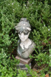 Aged garden statue nestled in greenery